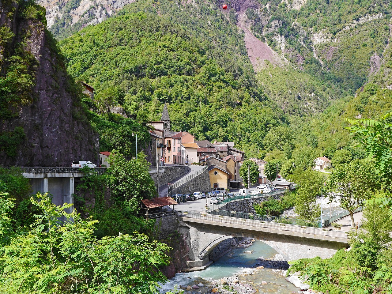 Vista panoramica del pittoresco villaggio alpino, circondato da montagne e natura incantevole.