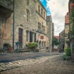 Vista panoramica dell'antica città medievale con l'auberge storica in primo piano.